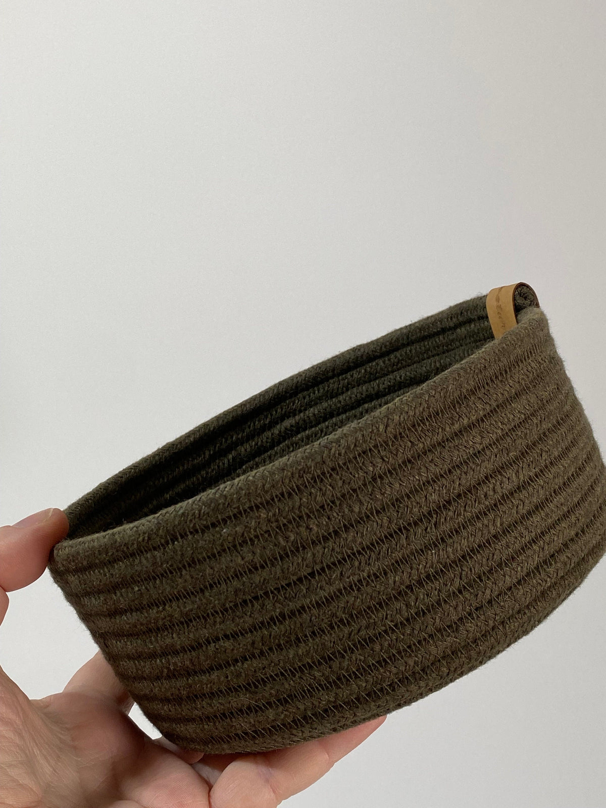 Cesta verde loden en un rincón del hogar
